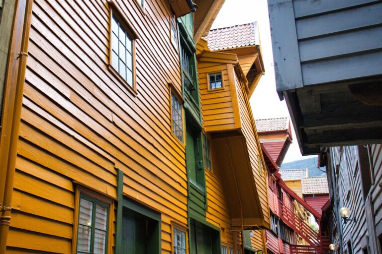Colorful wooden buildings line a narrow european street.