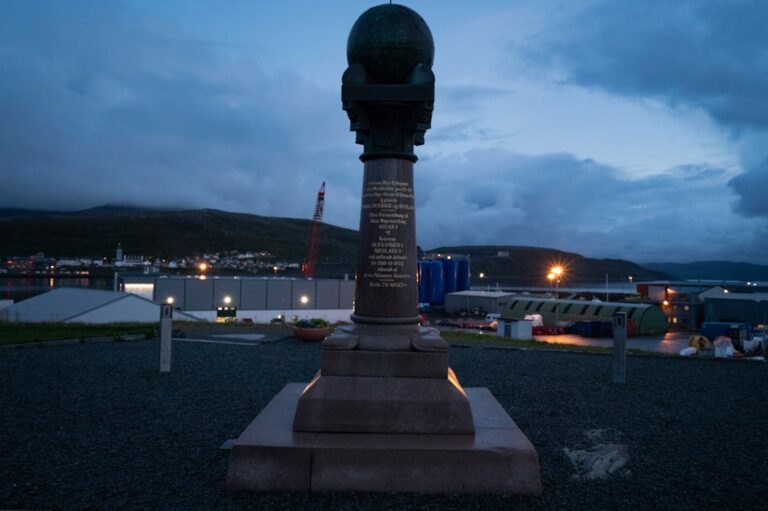 A clock tower sitting in the middle of a parking lot