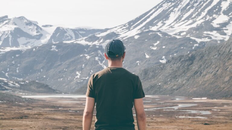 a man standing in front of a snowy mountain