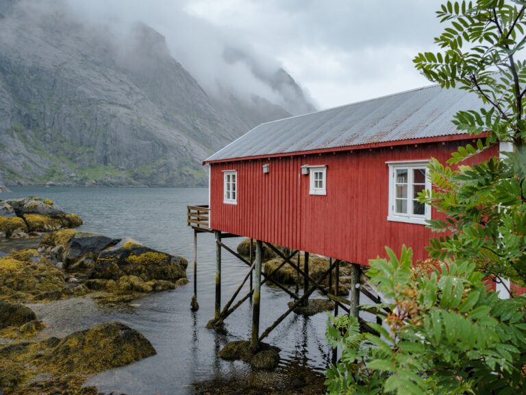 A red house sitting on top of a body of water